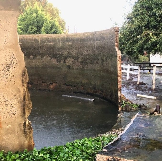 Concrete water tank with wall blown out.