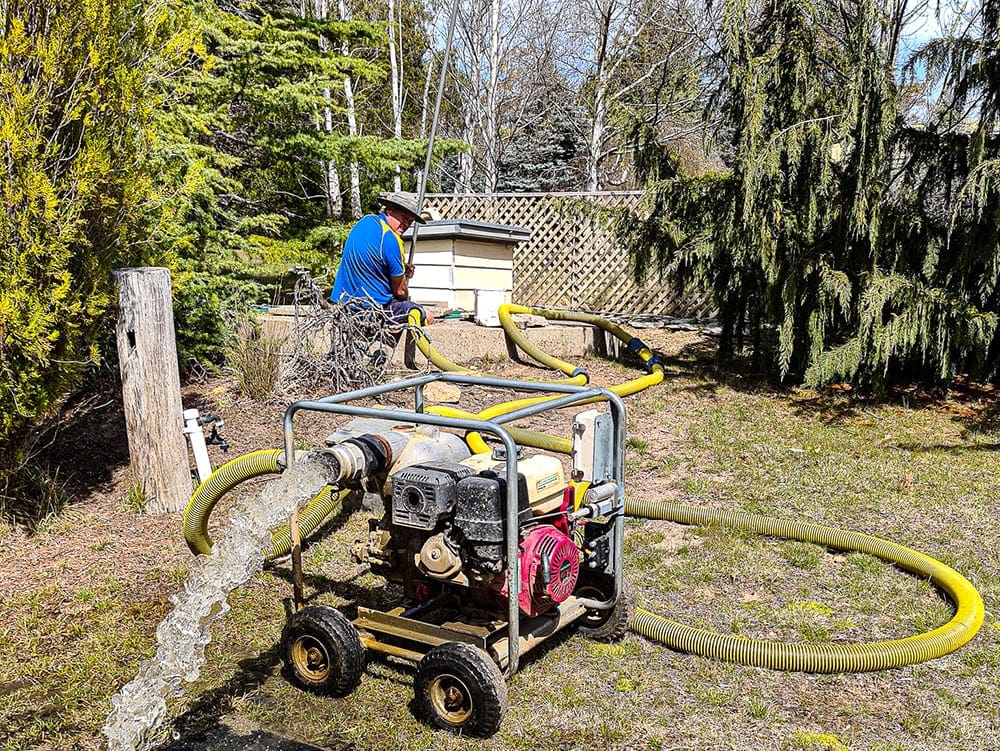 This image shows the clean water coming out of an above ground concrete water tank at the completion of the cleaning process.