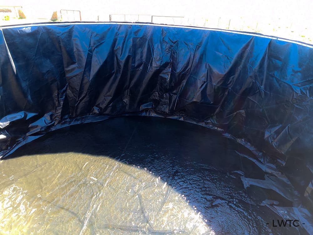 This image shows an open top water tank being refilled after a liner was installed in it.