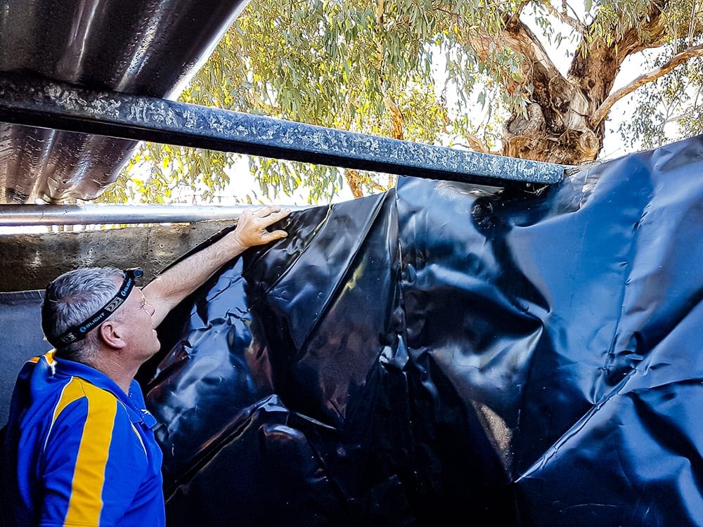 liner being pinned to the wall of a concrete water tank